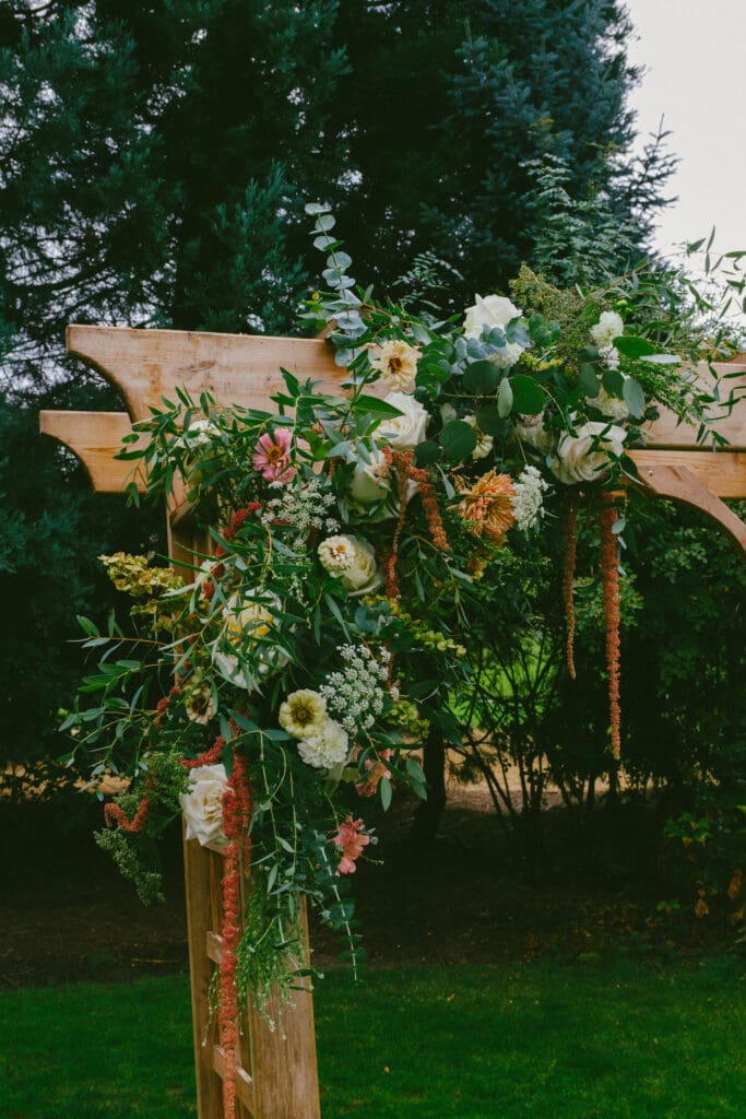 Close up of a floral wedding arch with greenery and garden flowers at an outdoor Pacific Northwest ceremony