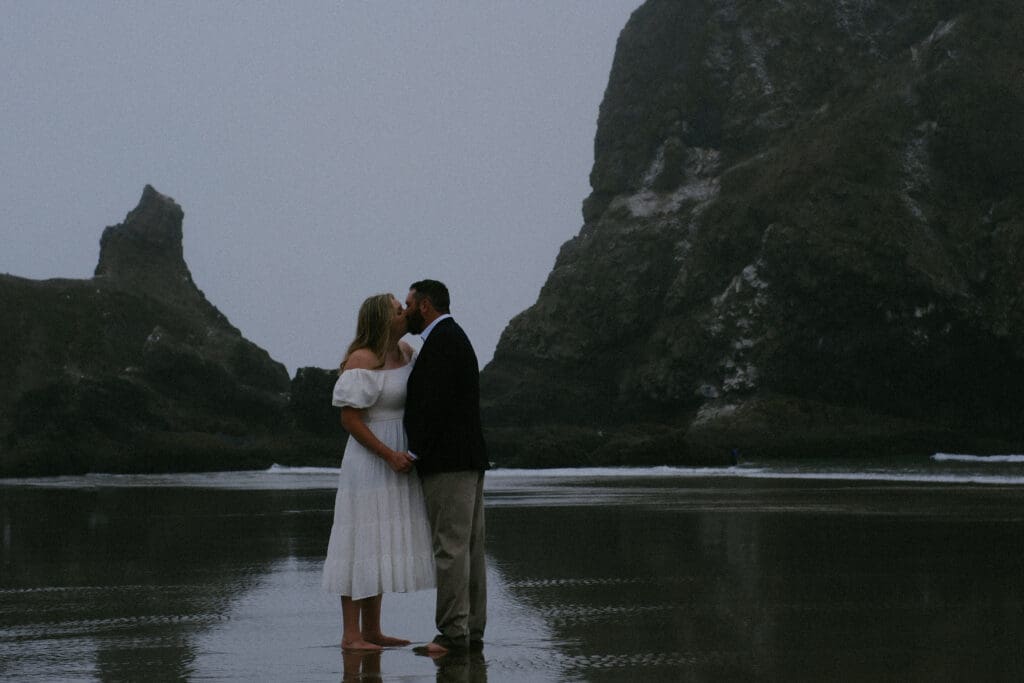 Bride and groom running barefoot along the shoreline during their Cannon Beach elopement.
