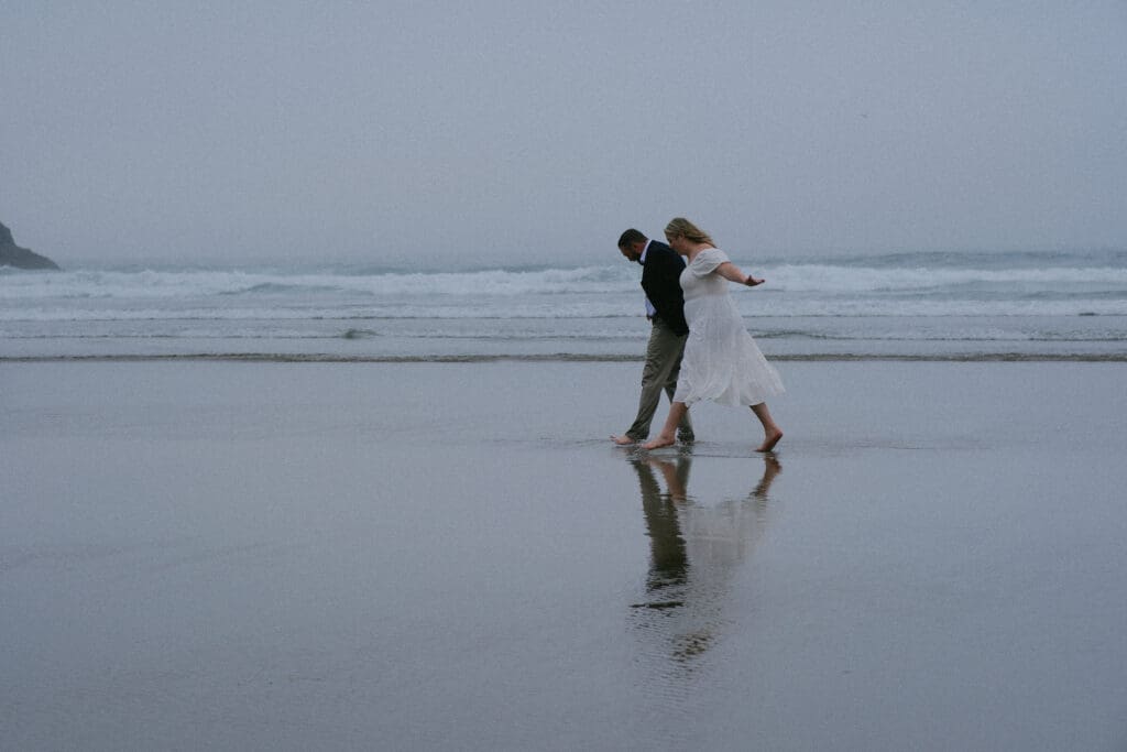 Groom twirling bride on the beach at sunset during an intimate Cannon Beach elopement.

