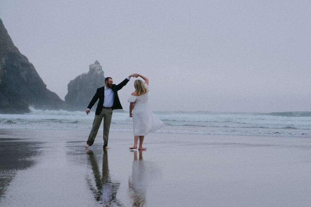 Couple walking side by side on the shoreline during a relaxed Cannon Beach elopement.
