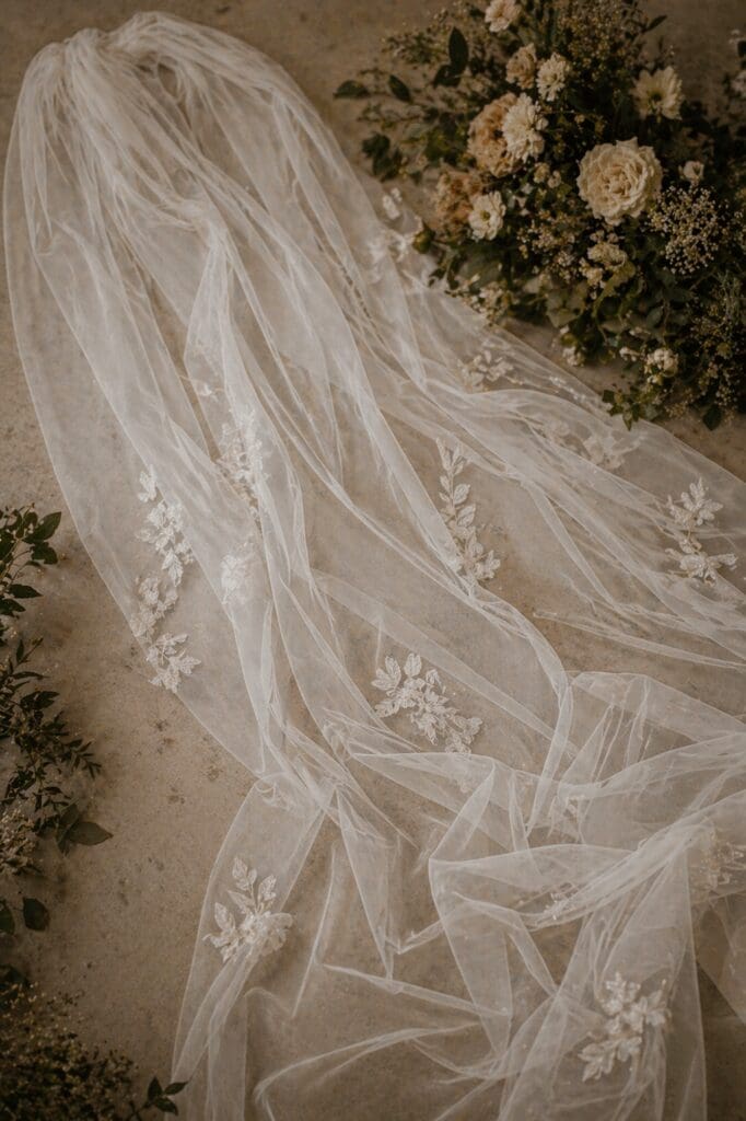 Wedding veil laid out with soft folds and delicate embroidery styled with florals for a romantic vineyard wedding at Eola Hills Legacy Estate in Salem Oregon