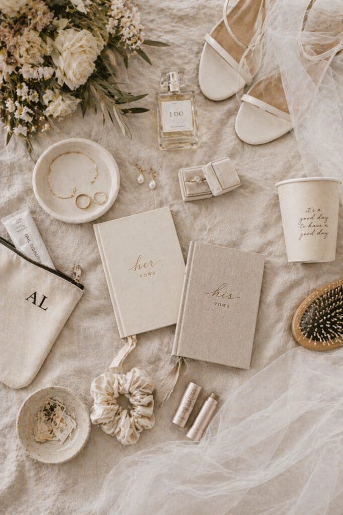 Wedding morning essentials flat lay with vow books, shoes, perfume, and soft neutral details styled for a modern indoor wedding in Salem Oregon