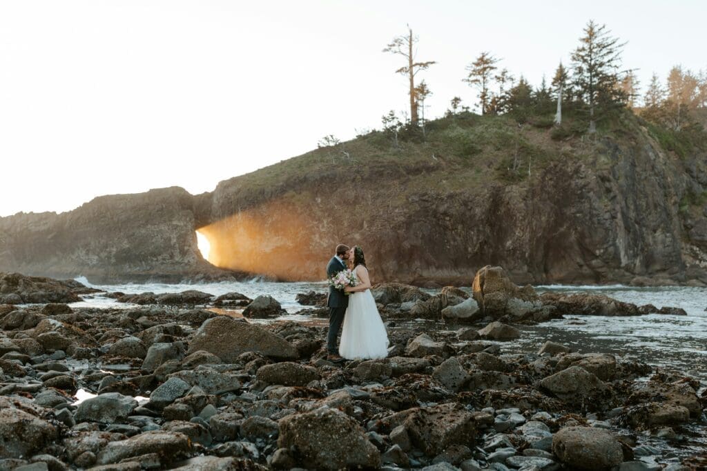 Couple kissing on a rocky beach near the Washington coast at sunset