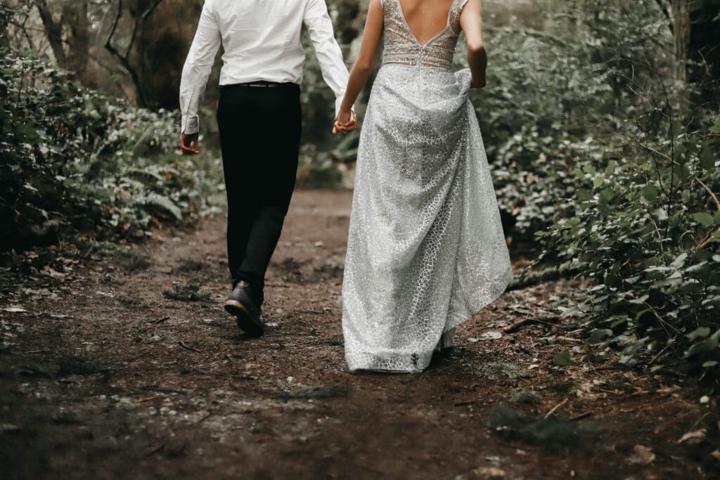 Couple walking hand in hand along a forest trail during a Washington elopement