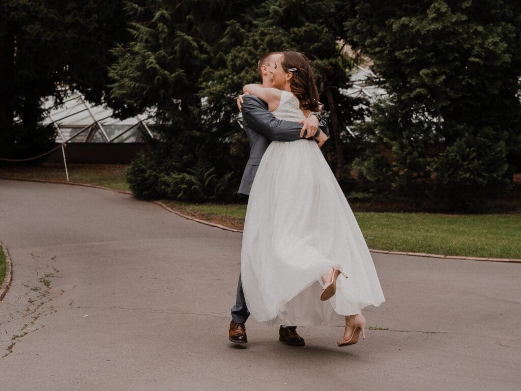 Groom lifting his bride after their intimate wedding at a garden venue in Eugene Oregon.