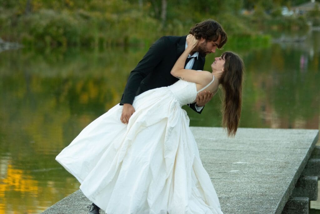 Couple sharing a romantic lakeside moment during a Washington State elopement beside a peaceful waterfront setting.