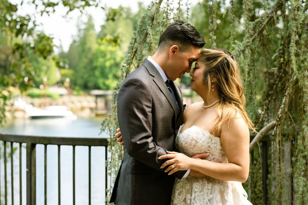 Bride and groom foreheads together beside the Willamette River, a Portland day of wedding coordinator moment at The Foundry