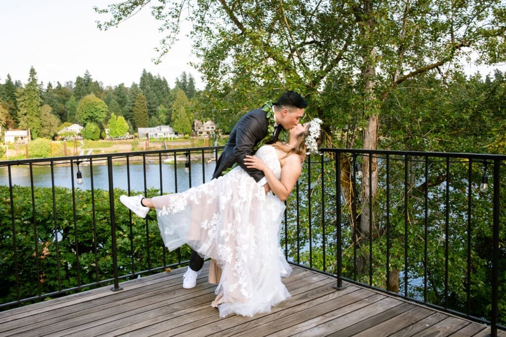 Golden hour dip kiss on the riverside deck at The Foundry, a Portland intimate wedding coordinator favorite