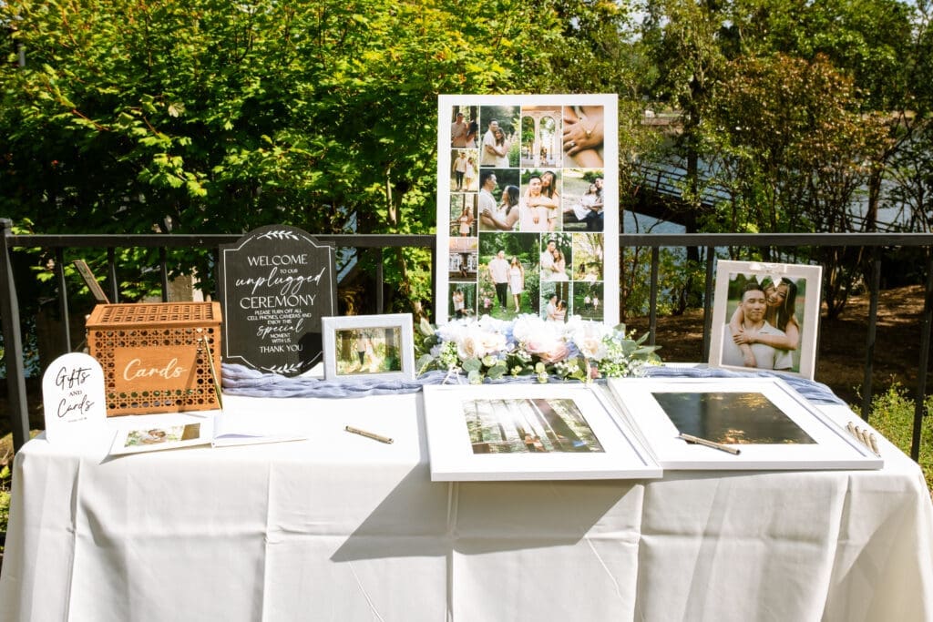 Riverside welcome table with a photo collage and guest book at The Foundry in Lake Oswego