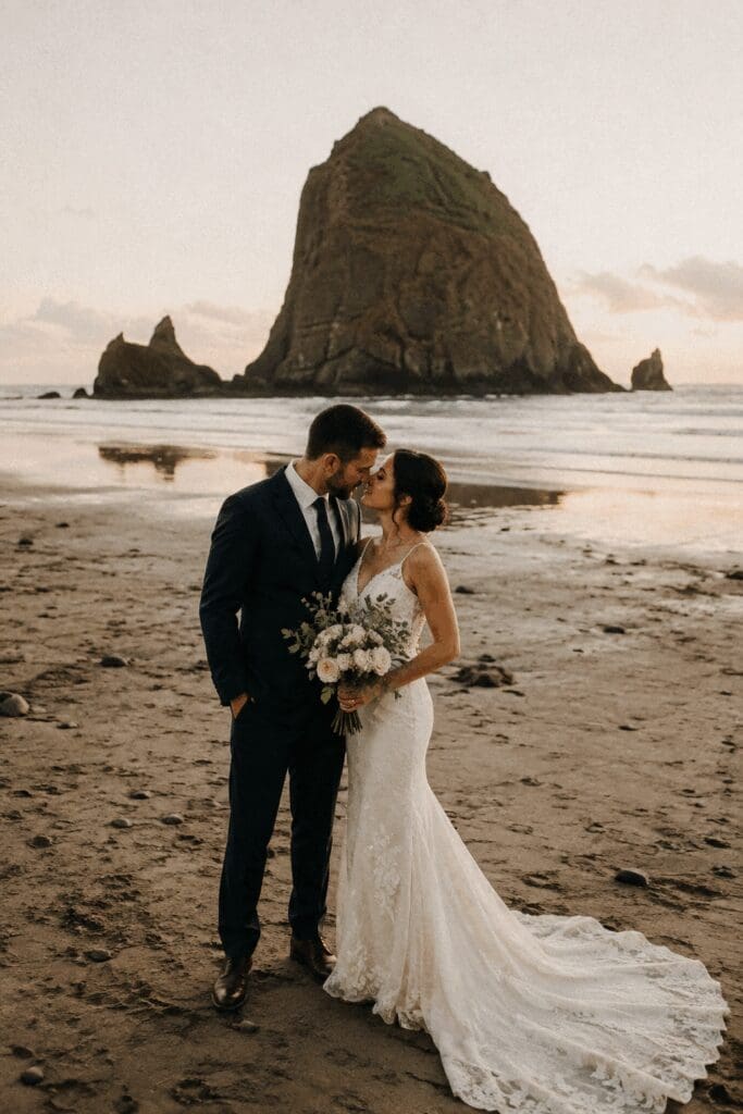 Wedding couple standing on Cannon Beach with Haystack Rock in the background