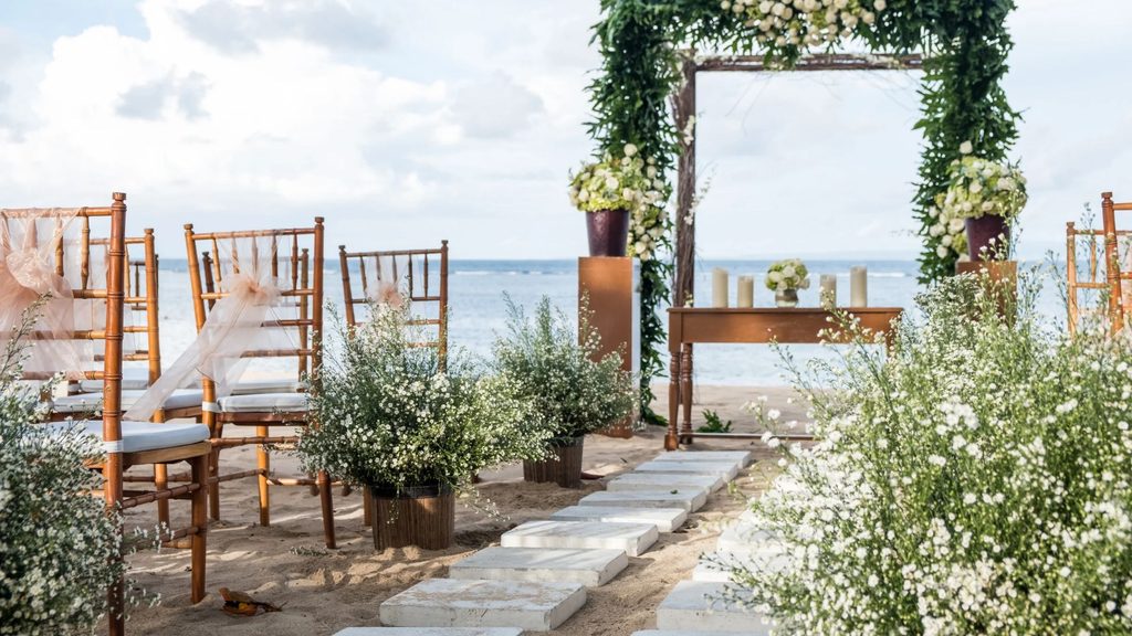 Beach wedding ceremony setup with wooden chairs, white flowers, and ocean views at an Oregon Coast micro wedding venue.