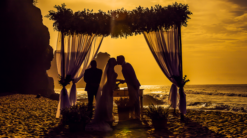 Couple exchanging vows during a sunset beach wedding ceremony on the Oregon Coast