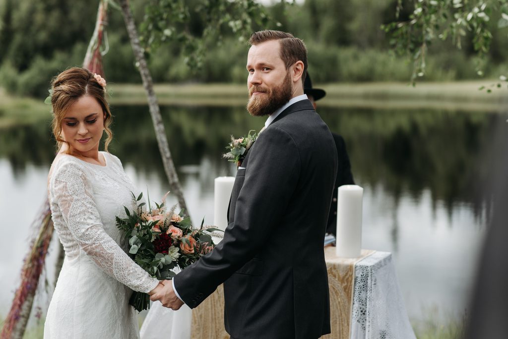 Couple holding hands during an intimate outdoor wedding ceremony with an officiant